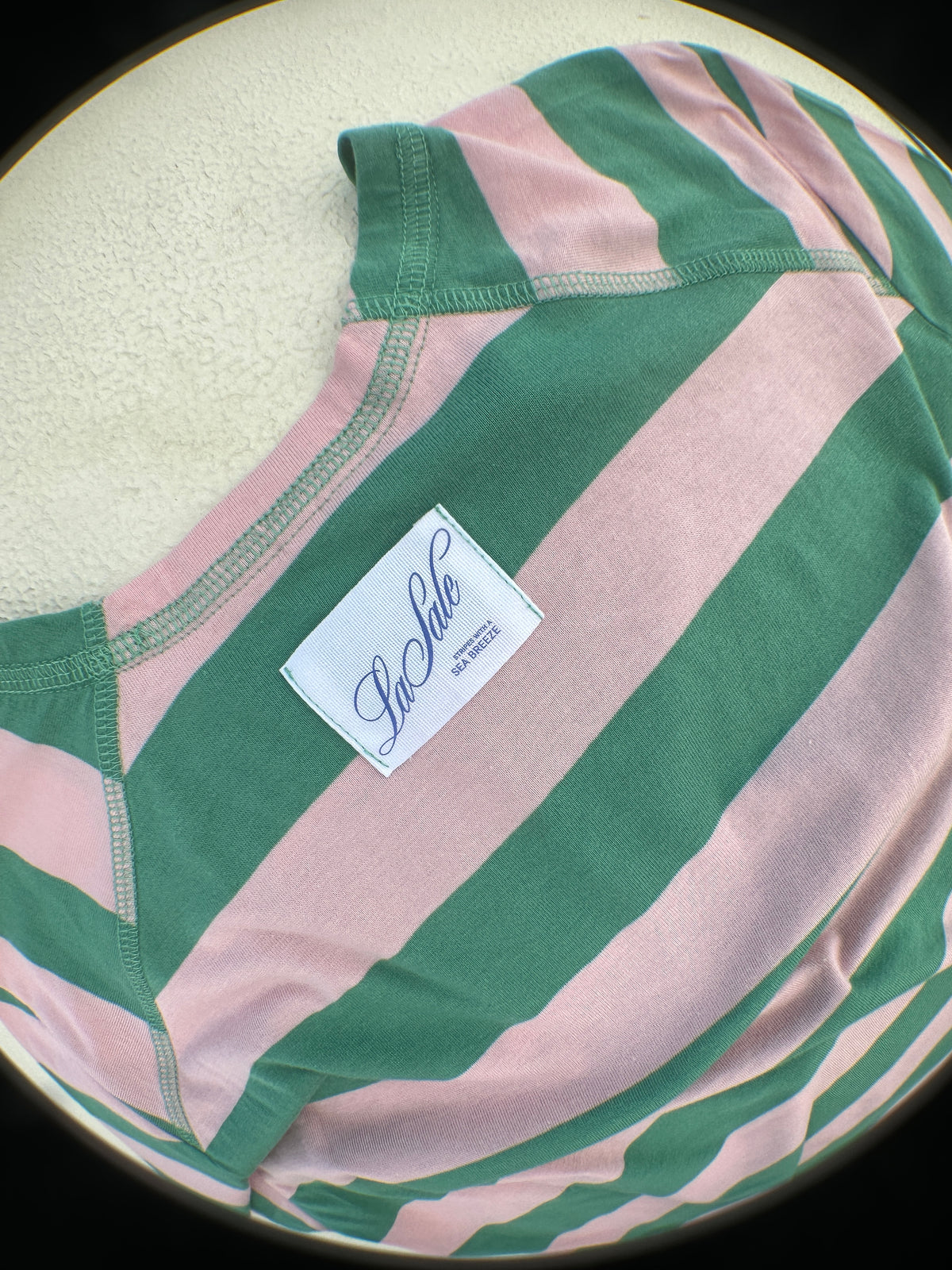 Detalle etiqueta "LASALE" en camiseta marinera rosa y verde 